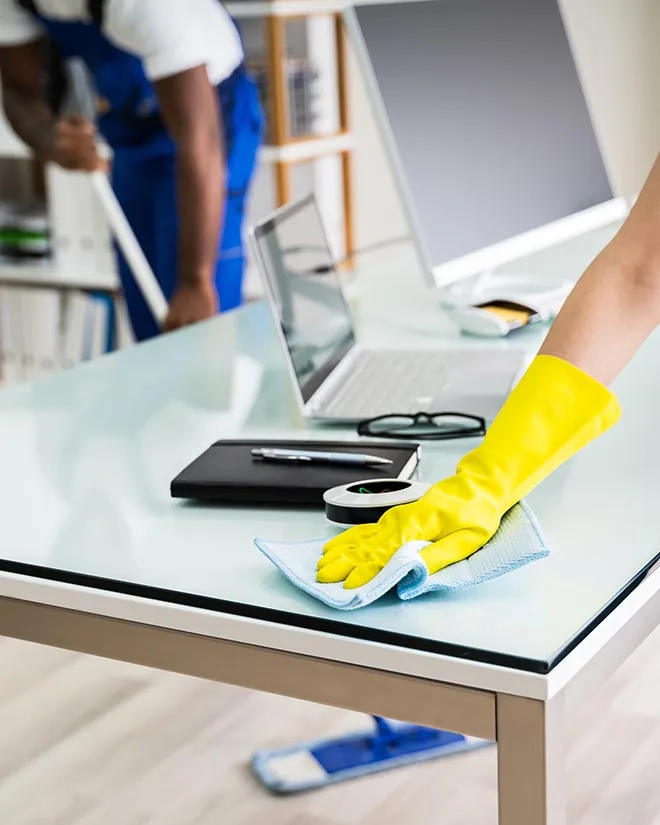 Janitor using cleaning equipment in a modern office lounge